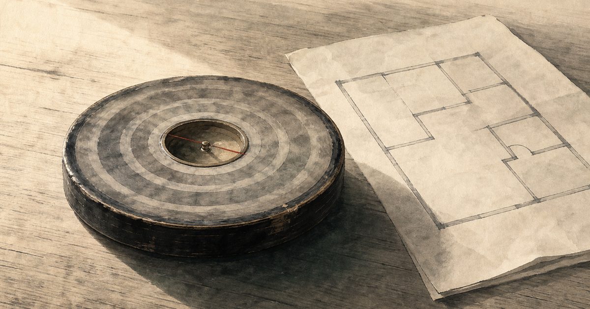 Ink-wash painting of a traditional Chinese wooden geomantic compass lying on a table beside a simple floor plan of a home, lit by low daylight.
